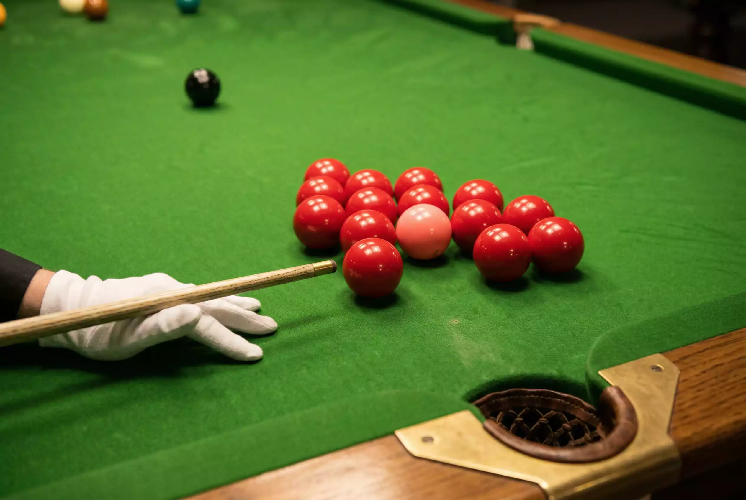 Nahaufnahme eines Snooker-Tisches mit roter Kugel am Rand der Tasche