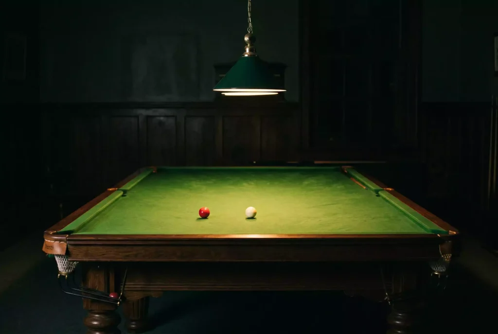 Dunkler Snooker-Tisch mit nur einer Lampe beleuchtet als Symbol für den Schwarzmarkt bei Sportwetten