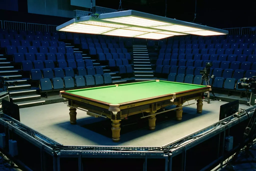 Snooker-Tisch in einer Turnierhalle mit Zuschauerrängen im Hintergrund als Symbol für den Turnierkalender