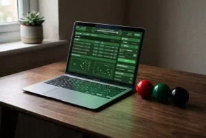 Laptop auf einem Schreibtisch mit Snooker-Bällen daneben als Symbol für lizenzierte Online-Sportwetten